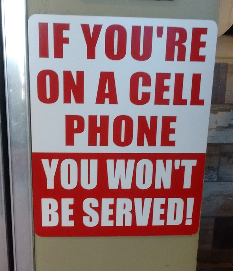 Sign at a local take-out shop. Risking their own business to do their parts to restore some semblance of civility to our technology-obsessed culture. Sign at a local take-out shop. Risking their own business to do their parts to restore some semblance of civility to our technology-obsessed culture.